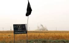 FILE: An Islamic State group (IS) flag and banner in Iraq. Picture: AFP.