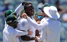 South African bowler Kagiso Rabada is embraced by teammates after he had taken his fifth wicket on day five of the first Test cricket match between Australia and South Africa in Perth on 7 November, 2016. Picture: AFP.