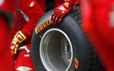 "Scuderia Ferrari technicians handle a wet Formula 1 Pirelli tyre at a Grand Prix. Picture: AFP