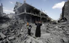 FILE: A Palestinian woman pauses amid destroyed buildings in the northern district of Beit Hanun in the Gaza Strip. Picture: AFP.