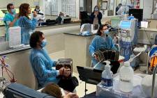 Bandoneonists Abril Farolini, 22, Ramiro Hernández, 35, and singer Paola Larrama, 37, perform at the dialysis room in the Diaverum Center for kidney patients, as part of the Hospital Tango project, in Montevideo on June 17, 2022. Picture:AFP.
