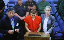 Hector Romero Asst. Public Defender (L) and Melisa McNeill, Public Defender (R) are seen on screen at the first appearance court for high school shooting suspect Nikolas Cruz (C) on 15 February 2018 at Broward County Court House in Fort Lauderdale, Florida. Picture: AFP