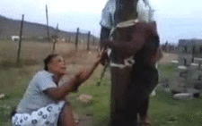 A screengrab of a KZN woman tying a boy accused of stealing a cellphone to a pole and beating him with a stick and a sjambok.