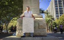 Johan Willemse of the Red October movement stands chained to the statue of Jan van Riebeeck in Cape Town to protest the vandalism of monuments across the country on 8 April 2015. Picture: Aletta Gardner/EWN