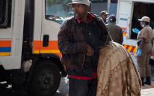 A homeless man from Doornfontein who is physically challenged struggles to lift some of his belongings which he will take to a shelter in Hillbrow. Picture: Ahmed Kajee/EWN