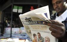 FILE: A newspaper consumer reads a copy of China Daily's Africa edition of its daily newspaper in front of a newsstand in the Kenyan capital in December 2012. Picture: AFP.