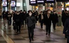 People walk at Shinagawa station in Tokyo on 13 January 2021 as Japan expanded the COVID-19 coronavirus state of emergency to seven more regions and tightened border restrictions. Picture: Philip Fong/AFP