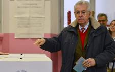 Italy's outgoing Prime Minister Mario Monti prepares to cast his ballot in a polling station on 24 February 2013 in Milan. Picture: AFP