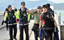 FILE: South Korean divers arrive at the harbour after attempting to rescue missing passengers of a capsized ferry in Jindo on 19 April 2014. Picture: AFP.