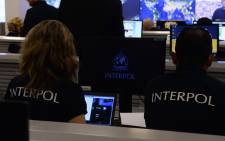 Interpol agents monitor an operation. Picture: AFP