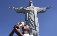 Jimmy Tau kisses the World Cup trophy replica during his visit at the Christ the Redeemer monument in Rio de Janeiro on 6 July 2014. Picture: Christa Eybers/EWN.