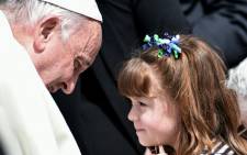 Pope Francis talks with five-year-old Lizzy Myers from the United States who suffers from a rare genetic disease which will take away her hearing and gradually make her blind, at the end of the Popes weekly general audience at Vatican on 6 April, 2016. Picture: AFP.