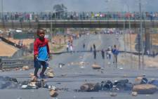 A small boy walks among the rubble strewn across the N1 highway at De Doorns on 9 January 2013. Picture: Aletta Gardner/EWN
