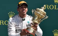 Mercedes AMG Petronas F1 Team’s British driver Lewis Hamilton raises the trophy on the podium after winning the British Formula One Grand Prix at the Silverstone circuit in Silverstone on 5 July, 2015. Picture: AFP.