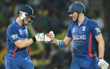 England cricketer Eoin Morgan (L) congratulates Luke Wright after a six during the ICC Twenty20 Cricket World Cup's Super Eight match between England and New Zealand in Pallekele on 29 September, 2012.. Picture: AFP.