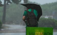 A man walks in the street during heavy rain and wind as tropical storm Eta approaches south of Florida, in Miami, Florida on November 8, 2020. Picture: AFP