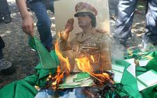 A portrait of Libyan leader Muammar Gaddafi is set on fire by demonstrators during a protest outside the Libyan embassy in Ankara on August 22, 2011. Picture: AFP