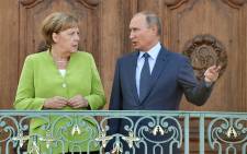 German Chancellor Angela Merkel and Russian President Vladimir Putin chat as they pose for the media on 18 August 2018 at Schloss Meseberg castle in Meseberg, northeastern Germany, where they meet to discuss conflicts in Syria and Ukraine as well as energy issues. Picture: AFP.