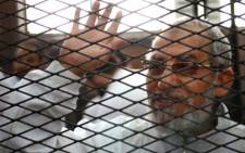 FILE: Egyptian Muslim Brotherhood’s supreme guide , Mohamed Badie waves from inside the defendants cage during the trial of Brotherhood members in February. Picture: AFP.