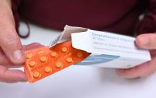 A pharmacist holds a box of dexamethasone tablets at a pharmacy in London on 16 June 2020. The steroid dexamethasone was shown to be the first drug to significantly reduce the risk of death among severe COVID-19 cases, in trial results hailed as a 'major breakthrough' in the fight against the disease. Picture: AFP