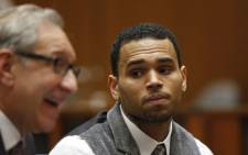 FILE: R&B singer Chris Brown (R) looks at his attorney, Mark Geragos, as he appears in court for a probation progress report hearing on 24 September 2012 in Los Angeles California. Brown pleaded guilty to assaulting his then-girlfriend, singer Rihanna, after a pre-Grammy Awards party in 2009. Picture: AFP.