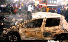 FILE: Nigerian firefighters and rescuers extinguish a fire at Terminus market in the central city of Jos after twin car bombings killed 118 and injured 45 on 20 May 2014. Picture:  AFP.