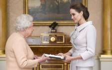 US actress-director Angelina Jolie is presented with the Insignia of an Honorary Dame Grand Cross of the Most Distinguished Order of St Michael and St George by Britain's Queen Elizabeth II at Buckingham Palace in London on 10 October 2014. Picture: EPA.