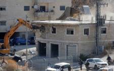 FILE: This picture taken from the West Bank on 22 July 2019 shows Israeli security forces tearing down one of the Palestinian buildings still under construction which have been issued notices to be demolished in the Wadi al-Hummus area adjacent to the Palestinian village of Sur Baher in East Jerusalem. Picture: AFP