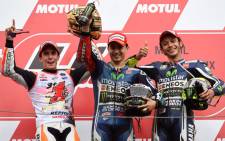 Japanese Grand Prix winner Movistar Yamaha MotoGP rider Jorge Lorenzo of Spain (C) poses with second placed Repsol Honda Team rider Marc Marquez of Spain (L) and third placed Movistar Yamaha MotoGP rider Valentino Rossi of Italy (R) on the podium at the MotoGP Japanese Grand Prix in Motegi, Tochigi prefecture on 12 October 2014. Picture: AFP/TOSHIFUMI KITAMURA