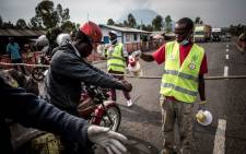FILE: A motor taxi driver gets his hands washed at an Ebola screening station on the road between Butembo and Goma on 16 July 2019 in Goma. Picture: AFP