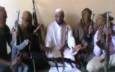A screengrab taken from a video released on YouTube apparently shows Boko Haram leader Abubakar Shekau (C) sitting flanked by militants. Picture: AFP.