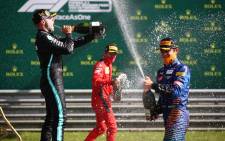 (L-R) Mercedes' Finnish driver Valtteri Bottas, Ferrari's Monegasque driver Charles Leclerc and McLaren's British driver Lando Norris celebrate with champagne on the podium after the Austrian Formula One Grand Prix race on 5 July 2020 in Spielberg, Austria. Picture: AFP