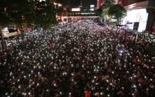 FILE: Pro-democracy protesters hold up flashlights on the phones during a demonstration in Bangkok on 15 October 2020, after Thailand issued an emergency decree following an anti-government rally the previous day. Picture: AFP