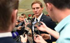 Stephen Larkham (C) speaks to the media at Sydney Airport on 28 October 2016 as the Wallabies depart for their European tour. Picture: AFP.