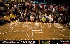 Malaysians take part in a candle-light vigil to mark the one-month anniversary of the missing Malaysia Airlines MH370 flight. Picture: AFP