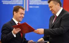 Ukraine’s President Viktor Yanukovych (R) and his Russian counterpart Dmitry Medvedev exchange folders after signing documents in Kiev. Picture: AFP