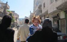 A young child with her mother in the streets of Darkoush, Syria. Picture: Rahima Essop/EWN.