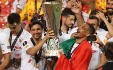 Sevilla's Spanish midfielder Jesus Navas (L) and Sevilla's Brazilian midfielder Fernando (R) hold the trophy as they celebrate after Sevilla won the UEFA Europa League final football match Sevilla v Inter Milan on 21 August 2020, in Cologne, western Germany. Picture: AFP