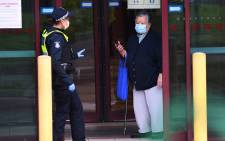 FILE: Police speak to a resident at the entrance of one of nine public housing estates locked down due to a spike in COVID-19 coronavirus numbers in Melbourne on 6 July 2020. Picture: AFP