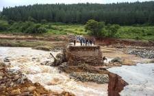 Timber company workers stand stranded on a damaged road on 18 March 2019, at Charter Estate, Chimanimani, eastern Zimbabwe, after the area was hit by the cyclone Idai.  Picture: AFP