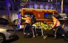 FILE: Rescuers evacuate an injured person on Boulevard des Filles du Calvaire, close to the Bataclan concert hall in central Paris, early on 14 November 2015. Picture: AFP.