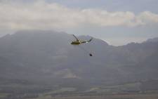 FILE: A helicopter water bombs a wildfire. Picture: EWN