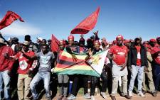 Movement for Democratic Change Alliance (MDC) supporters hold MDC and Zimbabwe flags as they gather to listen to their leader Nelson Chamisa during an election campaign rally on 21 July, 2018 at White City stadium in Bulawayo, Zimbabwe. Picture: AFP