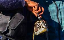 Police search a man's shoe for drugs, during a police operation in Westbury, Johannesburg, on 26 June 2013. Picture: Michelle Lubbe/EWN.