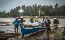 Fishermen carry a boat to higher ground in Baybay, eastern Samar on 24 December 2019, after typhoon Phanfone hit the central Philippines. Typhoon Phanfone smashed into the central Philippines on 24 December ruining Christmas plans as thousands were left stranded at ports or told to leave their homes. Picture: AFP.
