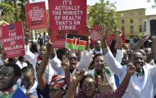 FILE: Kenyan doctors shout slogans and hold placards outside a Nairobi court on 26 January 2017 as they awaited for their union officials to come out. Picture: AFP.