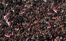 Egyptian demonstrators wave national flags and shout slogans in Cairo's Tahrir square on 25 November 2011. Picture: AFP