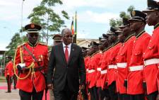 Tanzanian President John Magufuli reviews a military honour guard before attending the launching ceremony of a one-stop border post to speed up slow customs processing at the border in Mutukula, Uganda, on 9 November 2017. Picture: AFP
