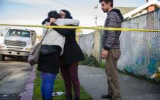 People mourn near a makeshift memorial on 4 December, 2016 in Oakland, California following a devastating fire that tore through a warehouse. Picture: AFP