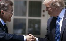 FILES) This file photo taken on 30 June 2017 shows South Korea's President Moon Jae-in and US President Donald Trump shaking hands in the Rose Garden of the White House in Washington, DC. Trump and Moon agreed on 4 September 2017, to remove limits on the payload of the South's missiles, Seoul's presidential office said, as the UN Security Co.